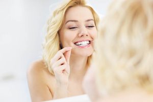 young lady flossing her teeth