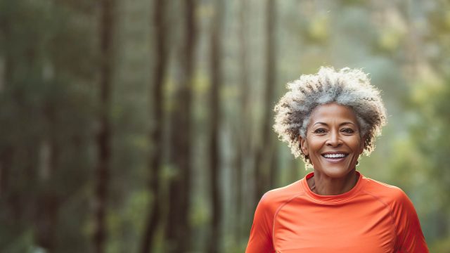 an older woman smiling in the forest