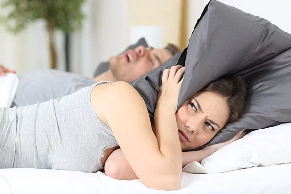 woman struggling to sleep due to her husband's central sleep apnea